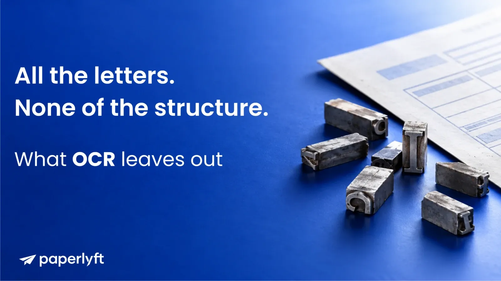 Loose metal letterpress type blocks scattered beside a printed document on a blue background.